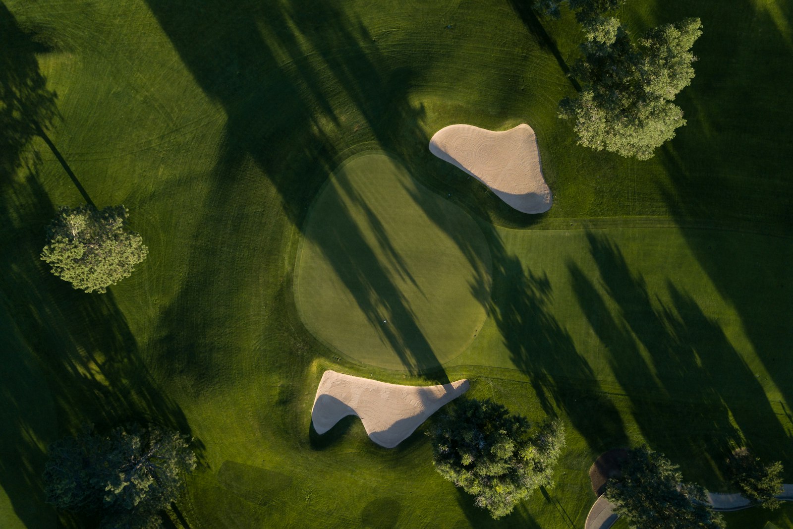 A manicured golf course green with sand bunkers, evoking Kansas City golf-course living